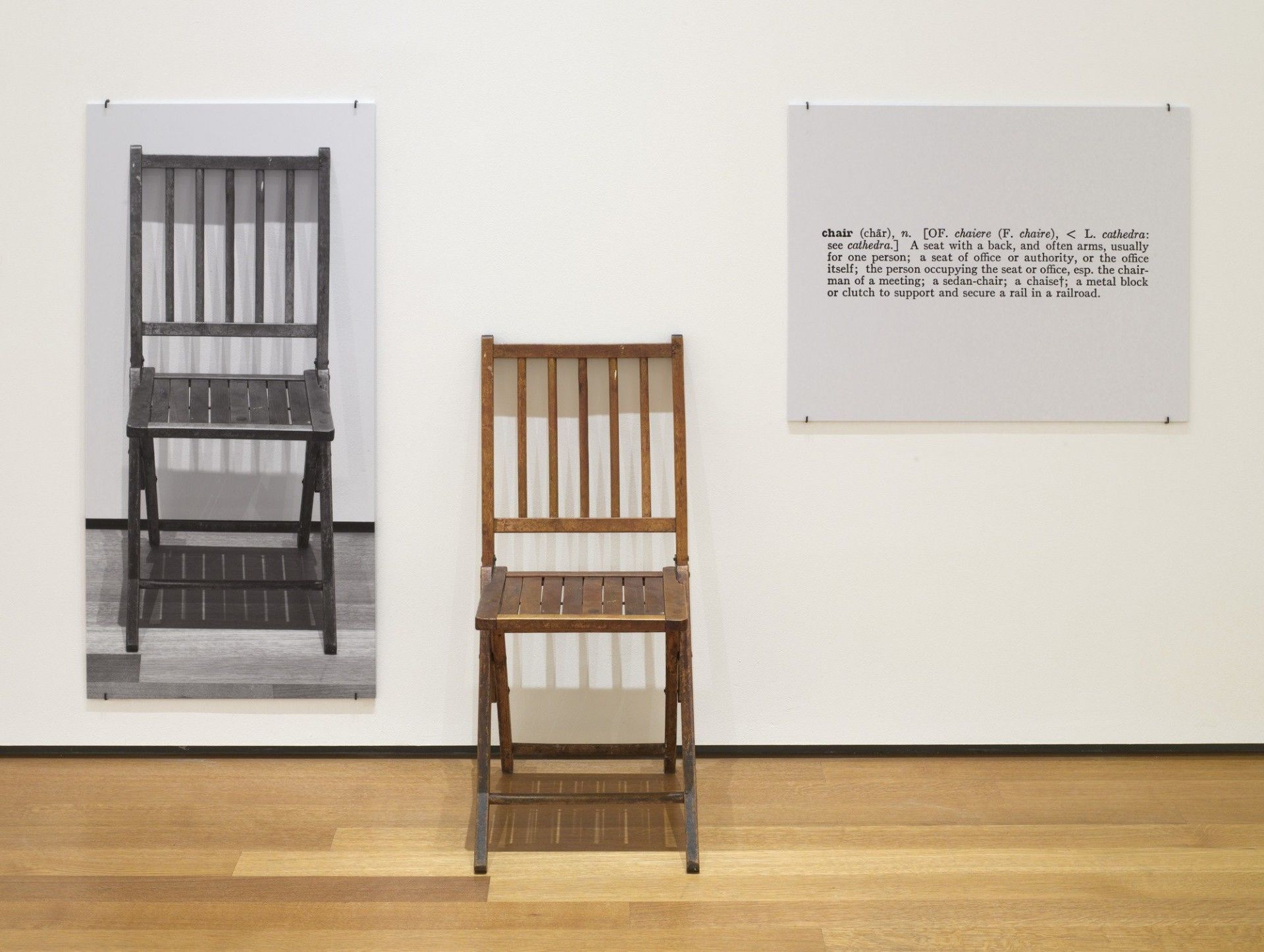 6. Contemporary Art Sample von Joseph Kosuth, One and Three Chairs, 1965. Klappstuhl aus Holz, montierte Fotografie eines Stuhls und montierte fotografische Vergrößerung der Definition von „Stuhl“, Museum of Modern Art, New York.